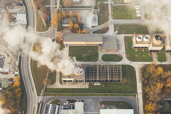 aerial shot of industrial buildings with white smoke
